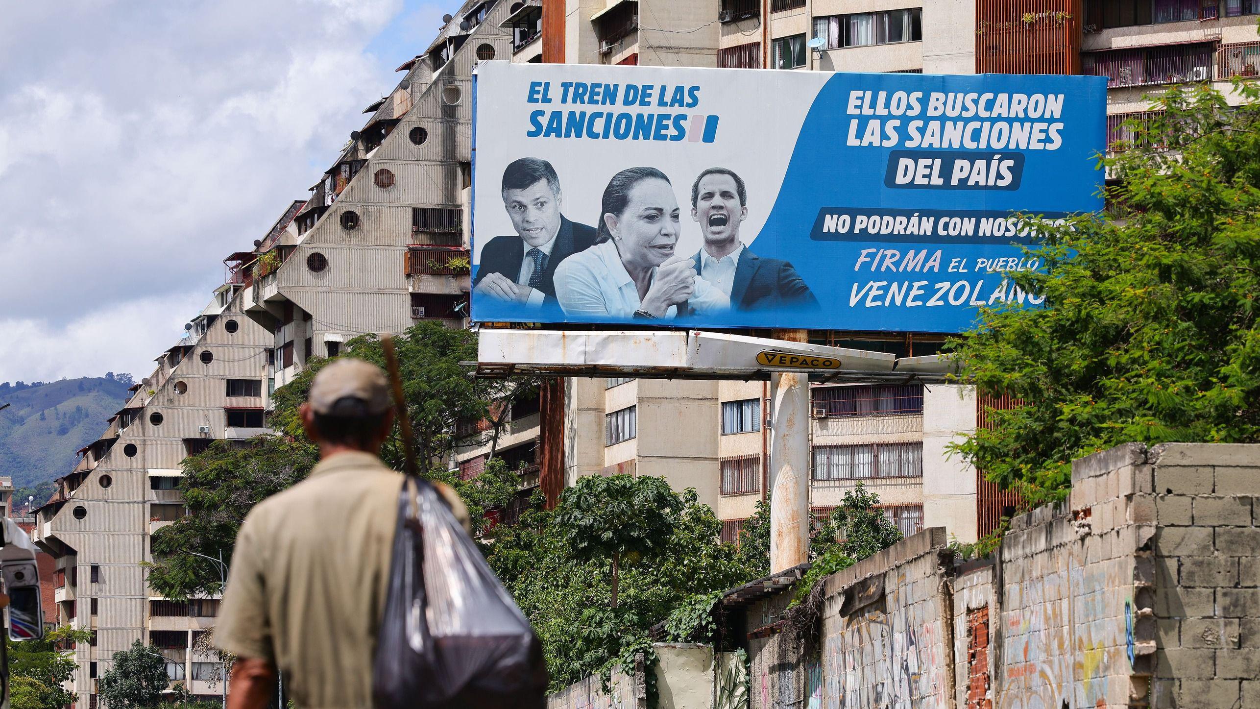 Una valla en Caracas muestra las caras de políticos opositores y la leyenda "Ellos buscaron las sanciones del país"