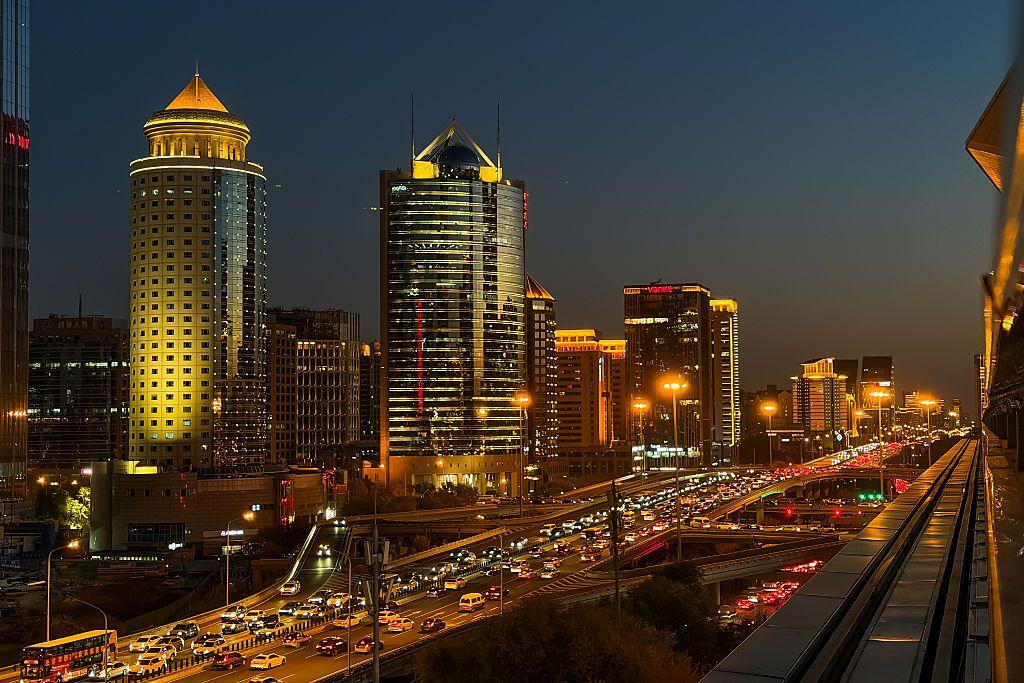 صورة ليلية تظهر مبانِ شاهقة واكتظاظ في حركة المرور في شوارع حديثة مضاءة في العاصمة الصينية بكين.