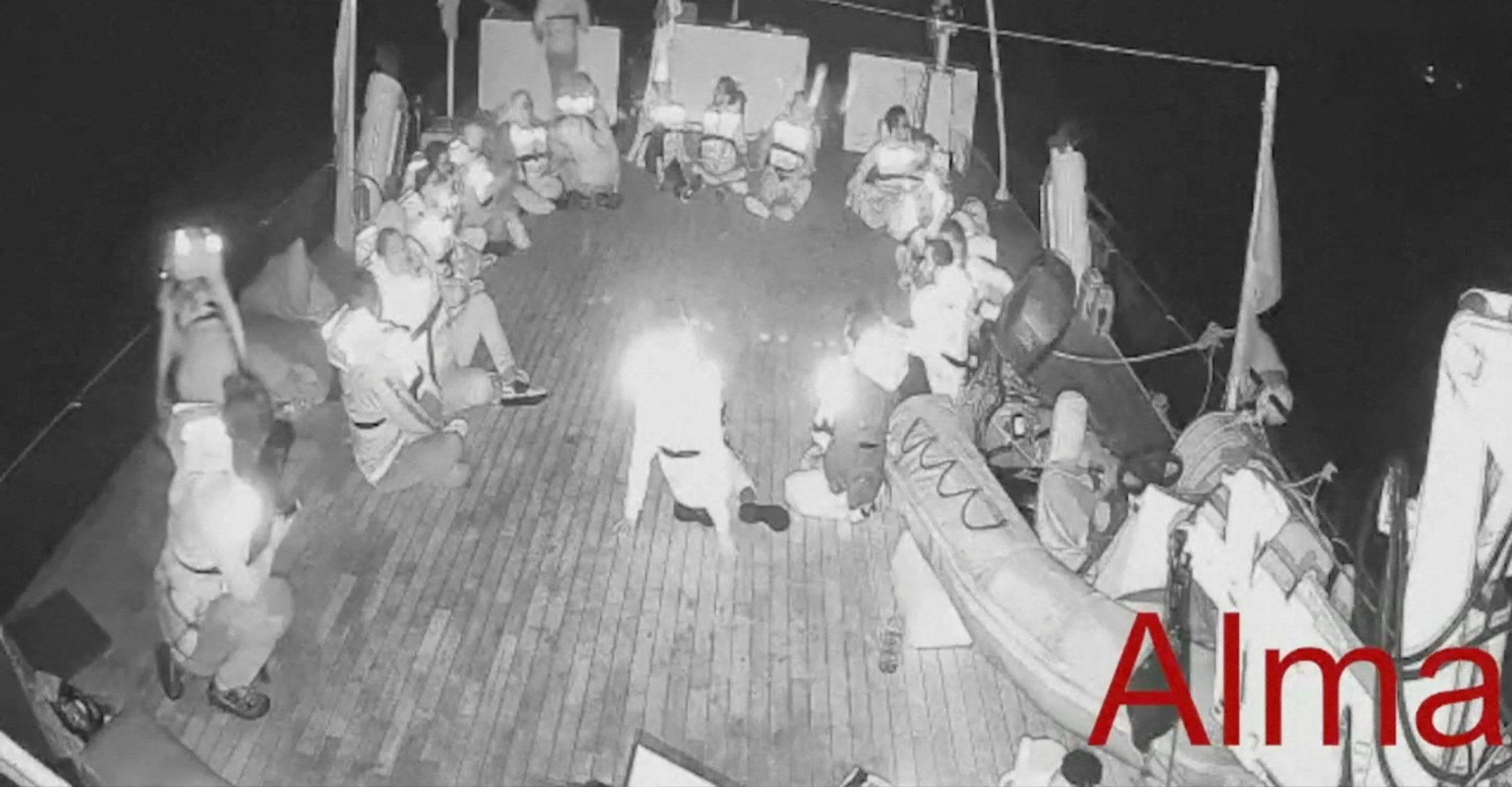 Tripulantes del barco "Alma" sentados alrededor de la cubierta del barco