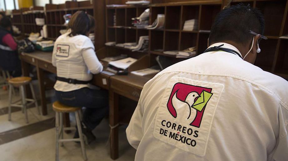 Trabajadores de Correos de México procesando paquetes