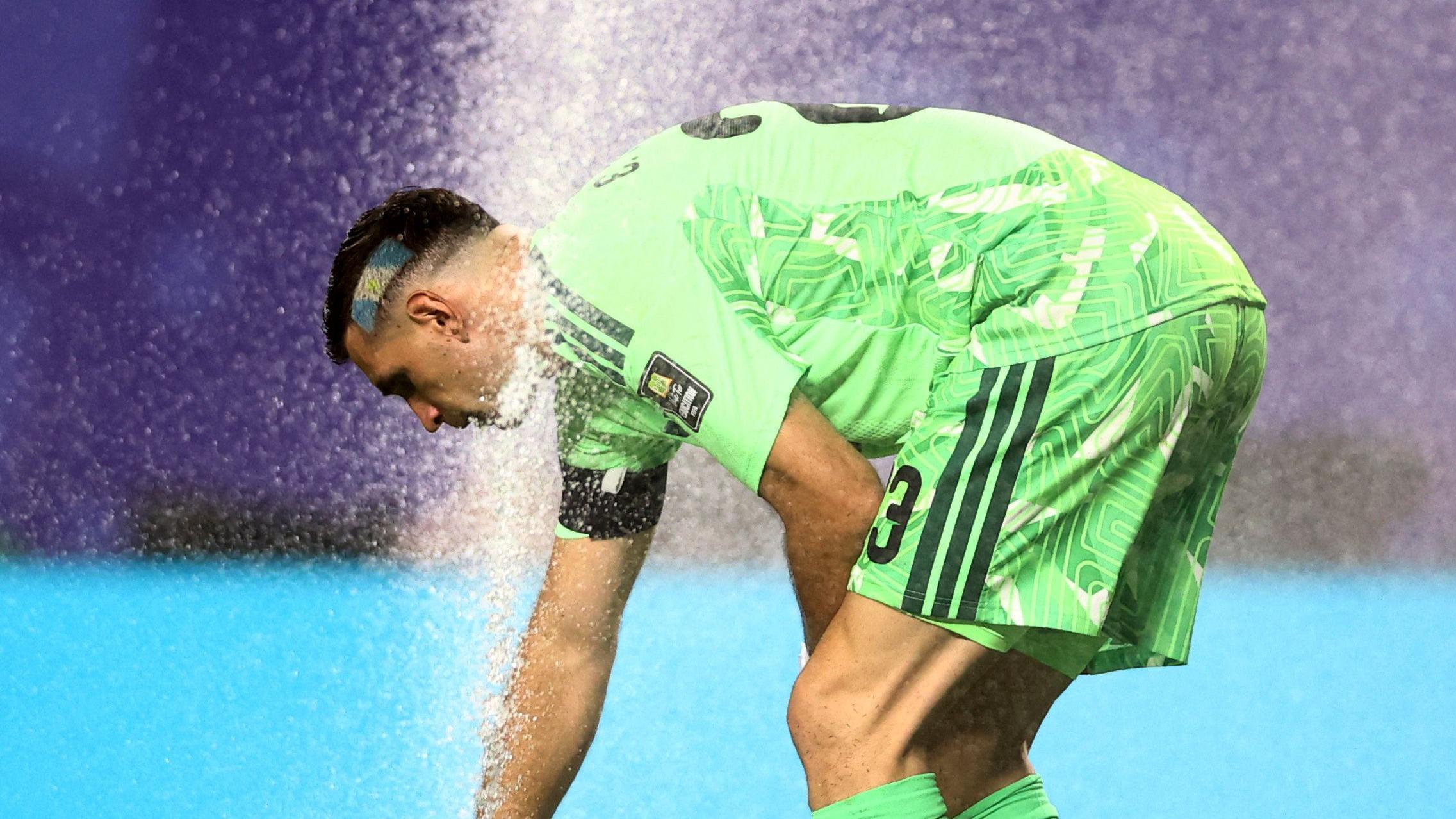 Argentinski golman Emilijano Martinez koristi prskalicu na terenu stadiona u Kanzas Sitija da se ohladi tokom pobede nad Švajcarskom od 3:1 u četvrtfinalu 