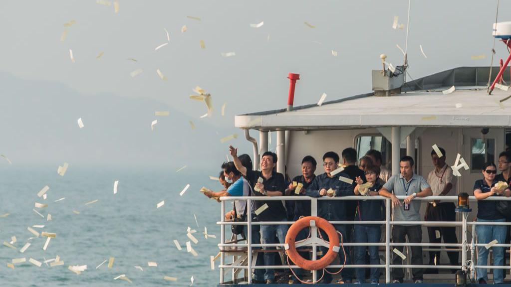 2012年10月4日，在香港南丫島附近海域舉行的渡輪碰撞事故罹難者悼念典禮上，哀悼者將紙錢拋入海中。