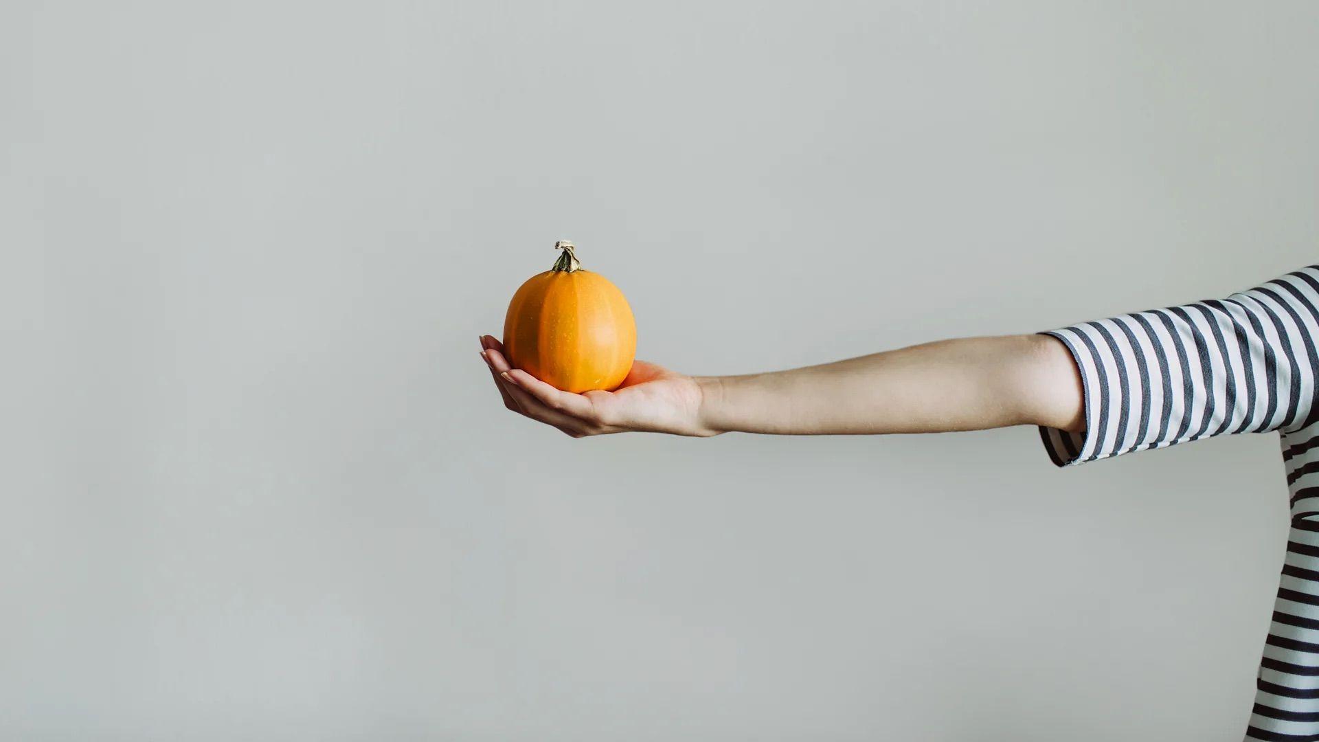 一位女性的手舉著一個水果