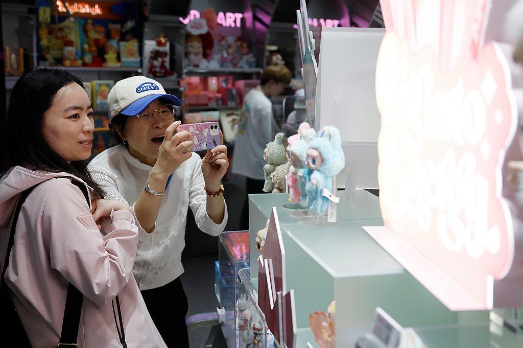 2025 年 6 月 11 日，中國上海，一位女士在泡泡瑪特全球旗艦店拍攝Labubu。