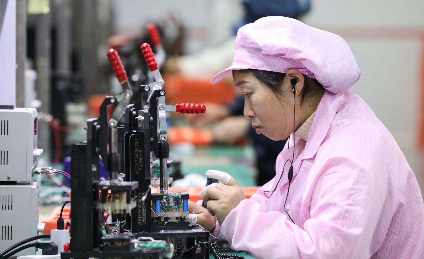 Mulher observando uma máquina de fabricação de chips