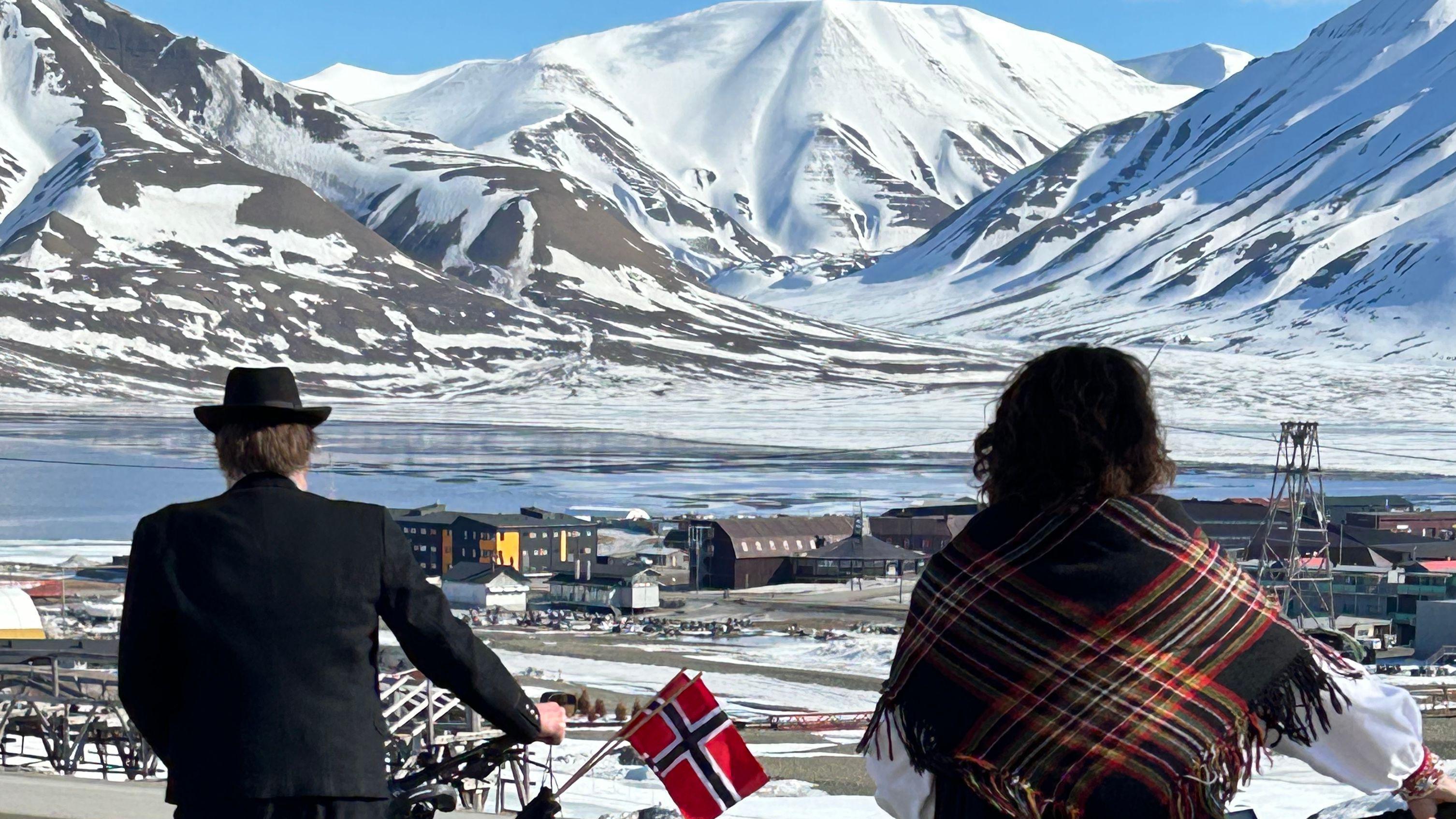 挪威人在國慶日騎著自行車穿越斯瓦爾巴群島（Svalbard），遠處是水和冰峰