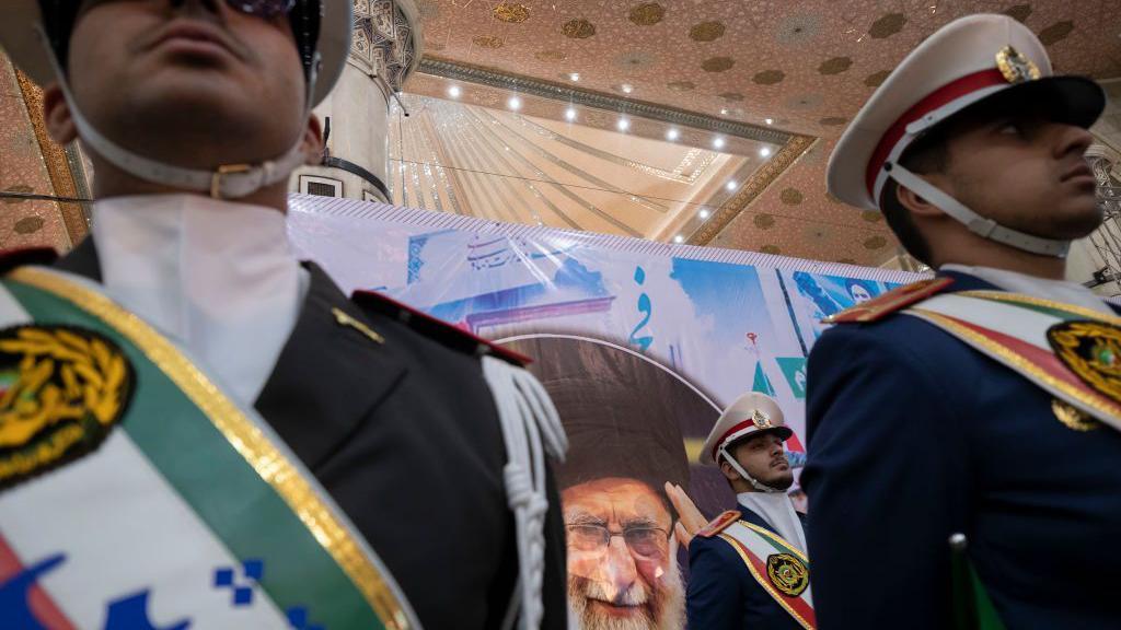 Membros da guarda de honra do exército iraniano em frente a um retrato do líder supremo do Irã, o aiatolá Ali Khamenei, durante uma cerimônia no sul de Teerã, no dia 1º de fevereiro de 2024