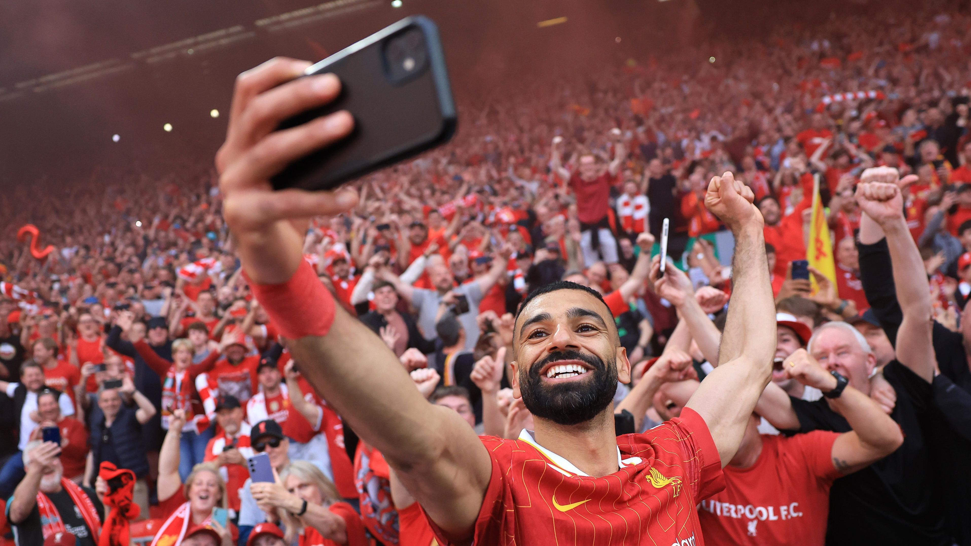 النجم المصري محمد صلاح يلتقط صورة مع مشجعي ليفربول بعد ضمان الفوز بالدوري الإنجليزي الممتاز