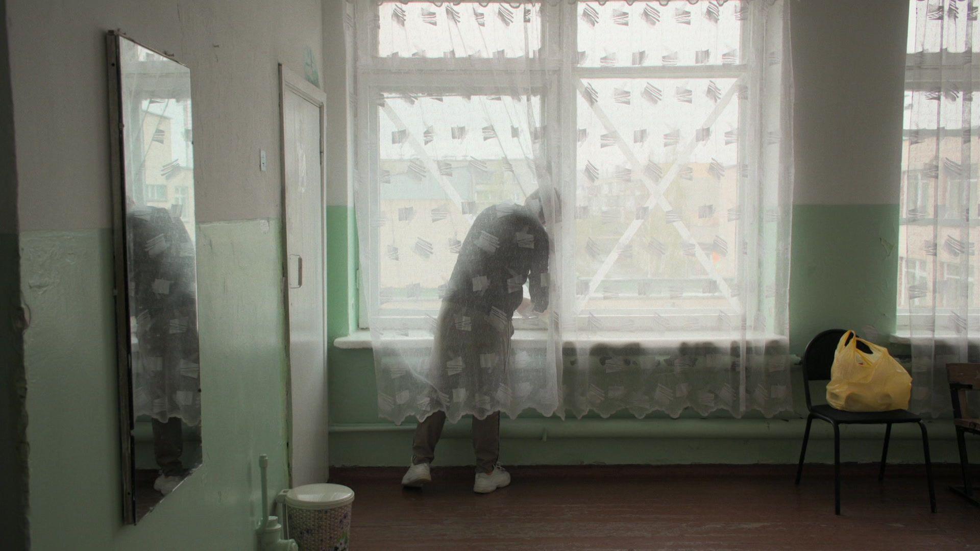 Pasha atr&aacute;s de uma cortina colocando X em janelas 