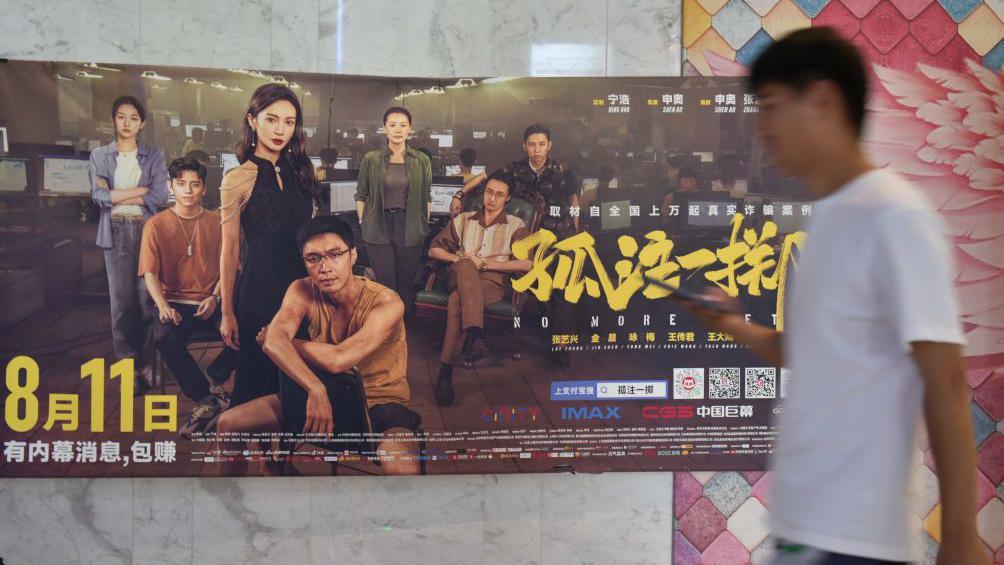 一名男子走過電影《孤注一擲》的海報。