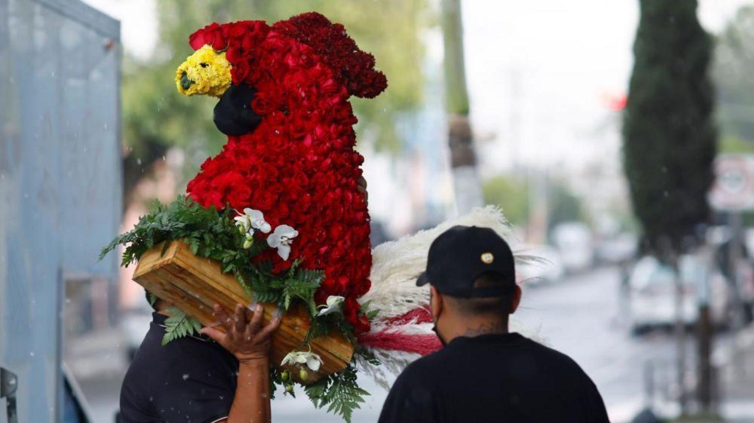 Un homenaje en forma de gallo estaba entre los arreglos florales, muchos de los cuales supuestamente fueron recibidos de remitentes sin nombre