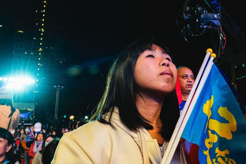 一名年輕女性正在參加台灣選舉競選活動。