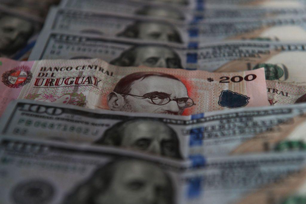 Billetes de dólares y pesos uruguayos