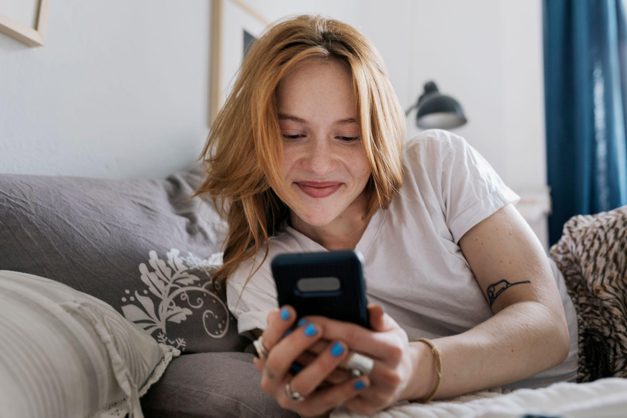 Mujer mirando el teléfono sonriendo