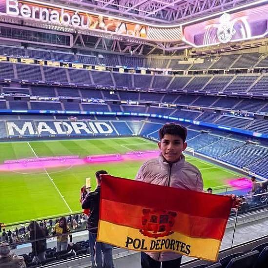 Cliver con una bandera que dice Pol Deportes en el Estadio Santiago Bernabéu en Madrid