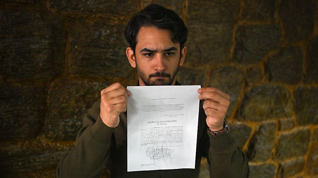 Ramón Guanipa sosteniendo copia de la boleta de excarcelación de su padre.