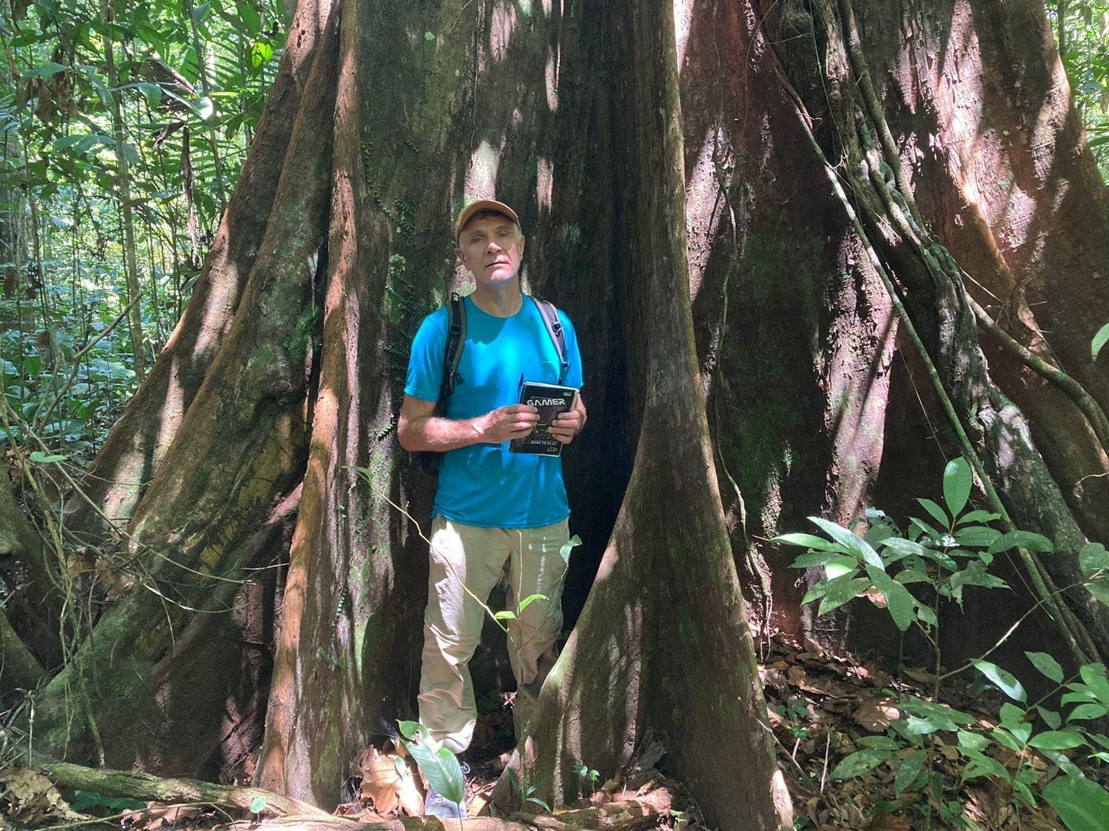 Dom posa para foto em frente a enorme árvore