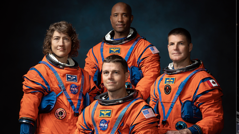 Quatro astronautas da Artemis II em seus trajes de voo laranja brilhante. 