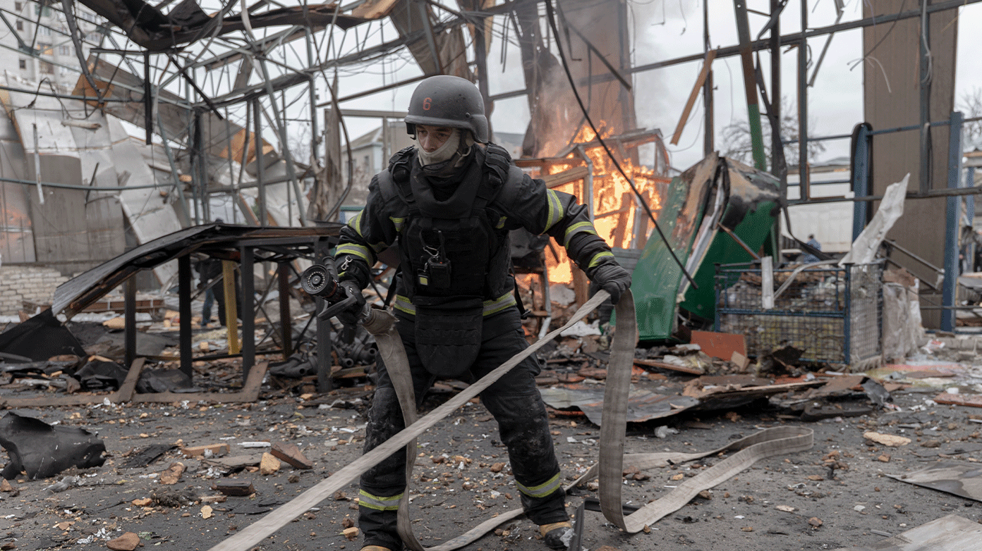  Trabalhadores dos serviços de emergência na Ucrânia atendem a um incêndio em um hangar destruído por um ataque de drone. 
