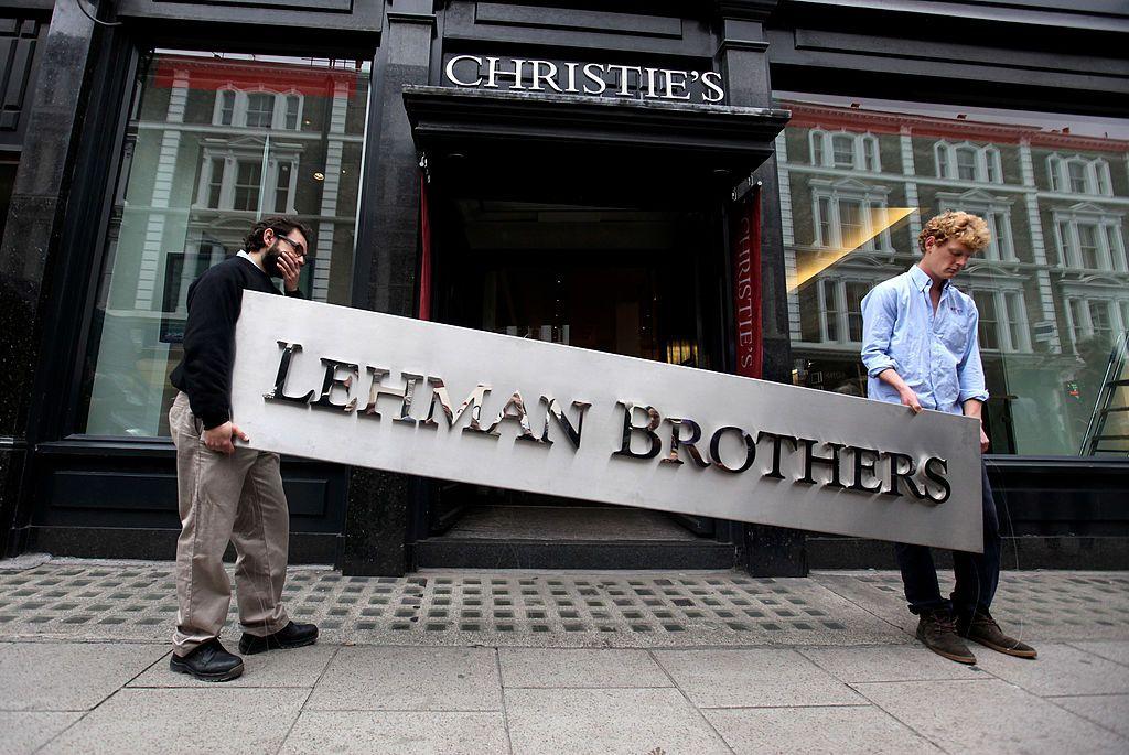 Duas pessoas seguram uma placa em apoio ao Lehman Brothers em frente &agrave; Christie's