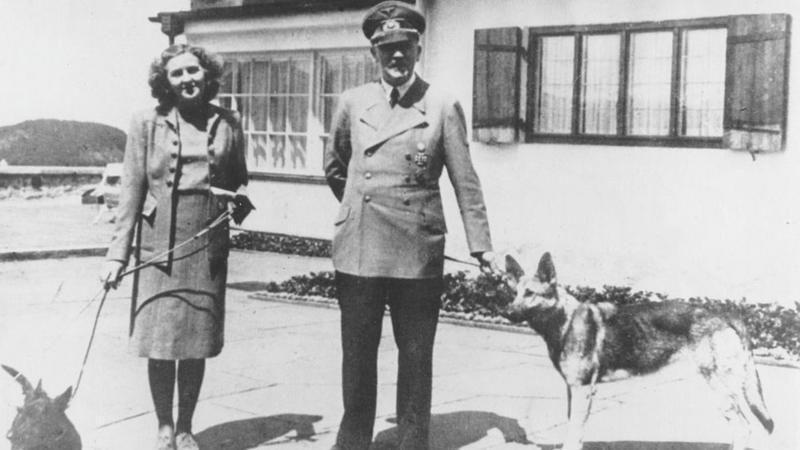 Adolf Hitler e Eva Braun com seus cães, no jardim de uma casa