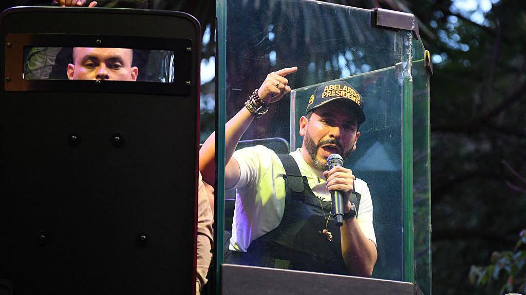 Abelardo de la Espriella, en un acto de campaña usando chaleco antibalas y protegido por escudos blindados. 