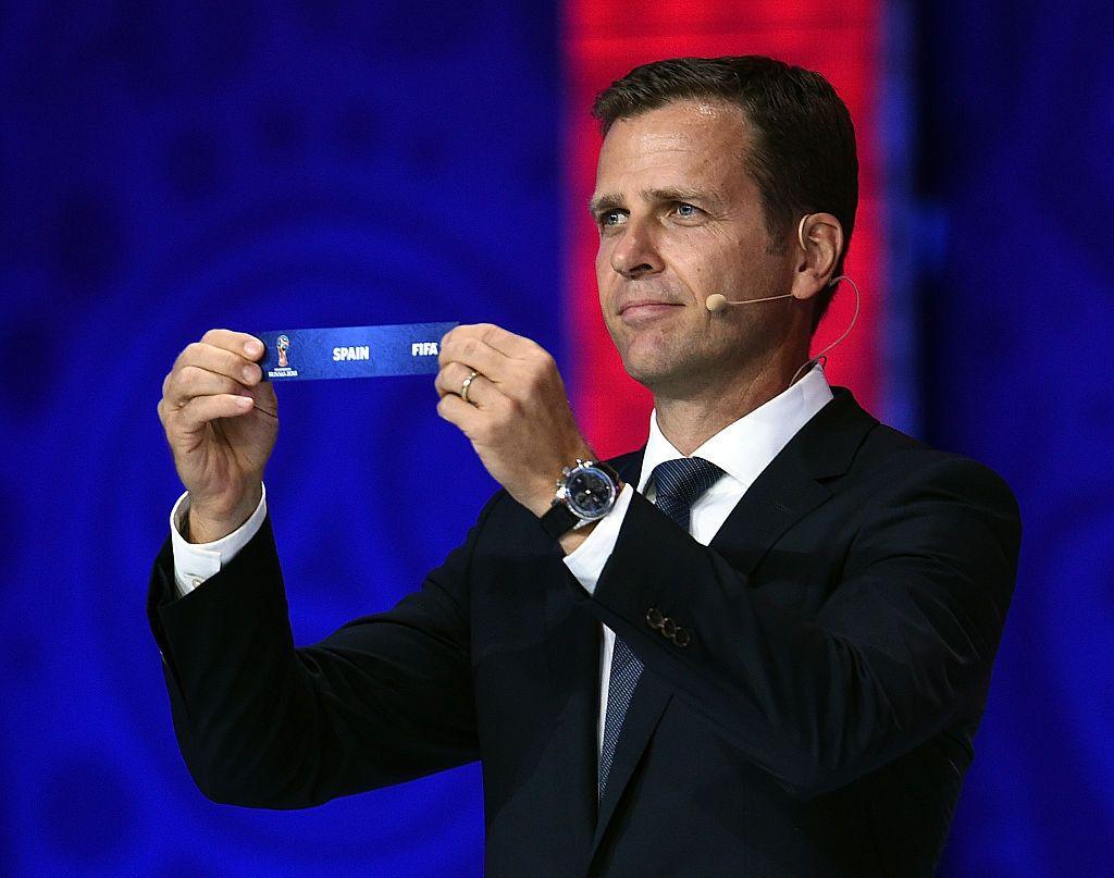 El exfutbolista Oliver Bierhoff sostiene el cintillo con el nombre de España durante un sorteo de la FIFA en 2018