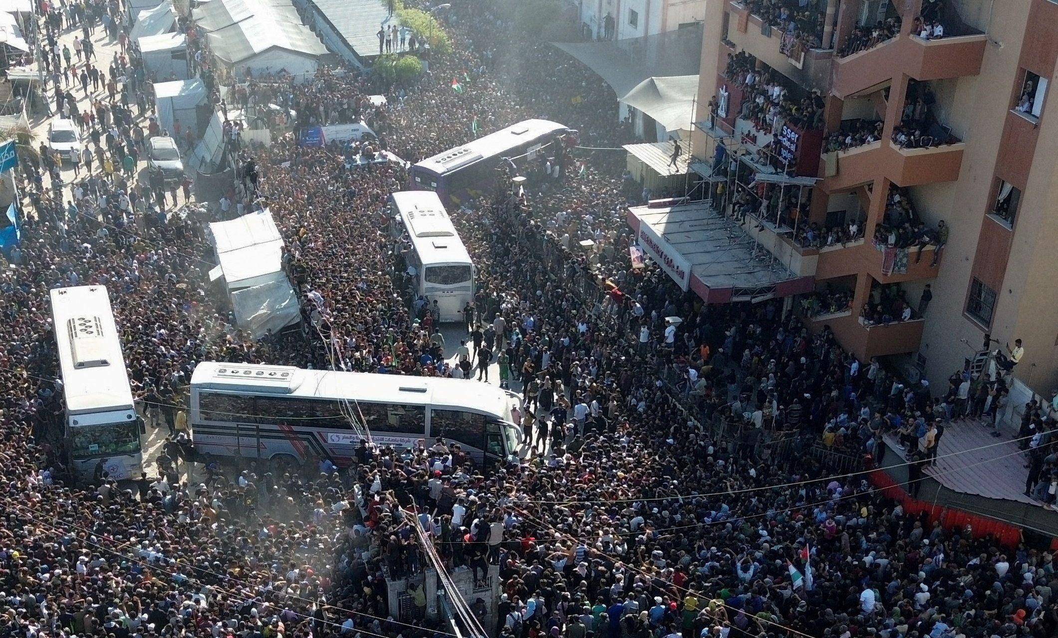 Una multitud recibe a los autobuses en los que viajan los detenidos palestinos liberados por Israel.