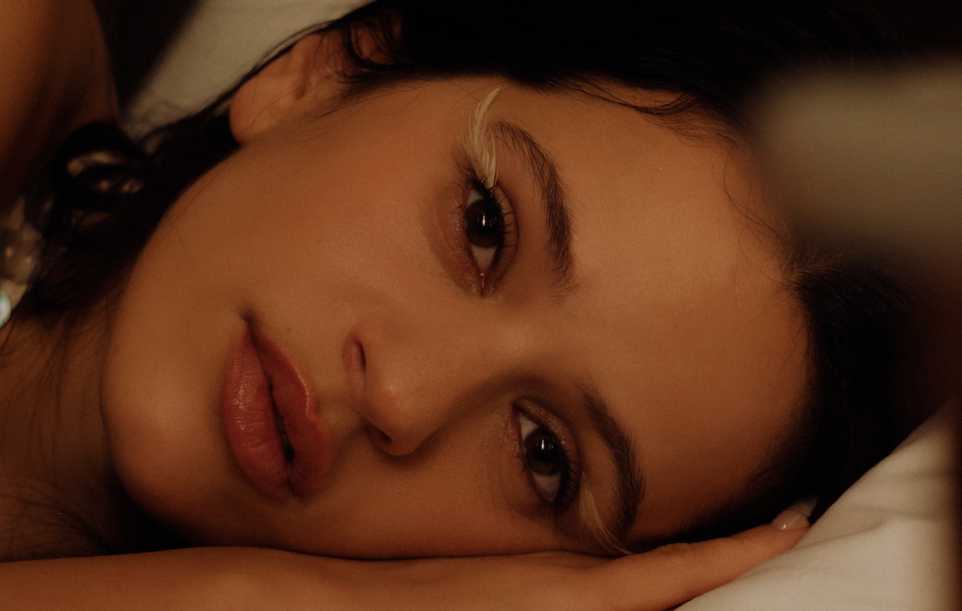 Rosalía con la cabeza recostada y mirada serena