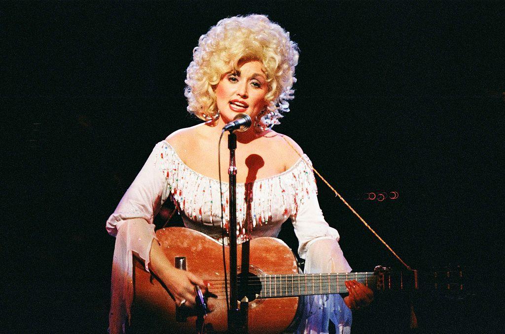 Dolly Parton con una guitarra en la década de 1970
