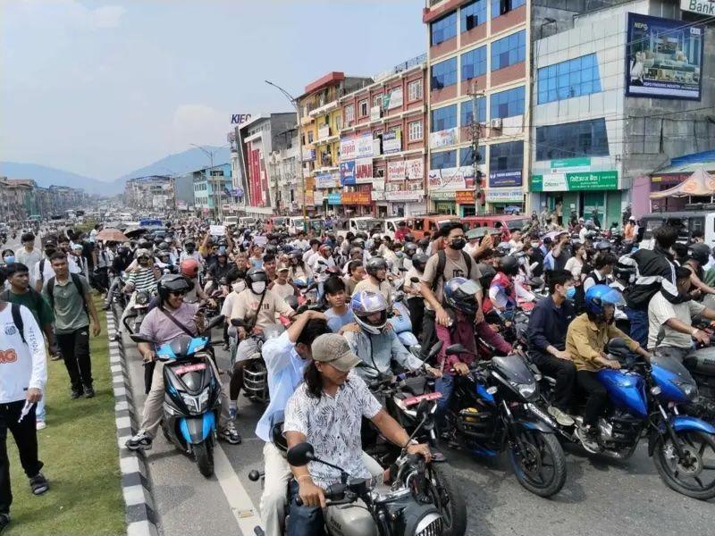 2025年9月8日，數十名騎自行車的人在居民樓前的道路上排成一排，而人們則沿著道路兩條車道之間的中央隔離帶行走
