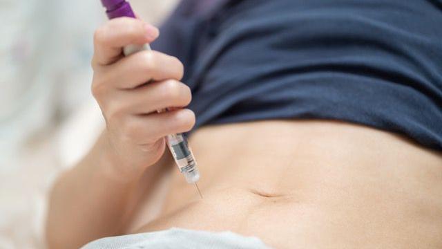 Mulher aplicando inje&ccedil;&otilde;es em si mesma para estimula&ccedil;&atilde;o ovariana.