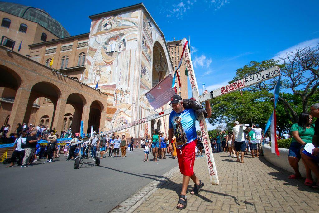 Um devoto carrega uma cruz enquanto presta homenagem a Nossa Senhora Aparecida, na basílica de mesmo nome em Aparecida, em 12 de outubro de 2024.