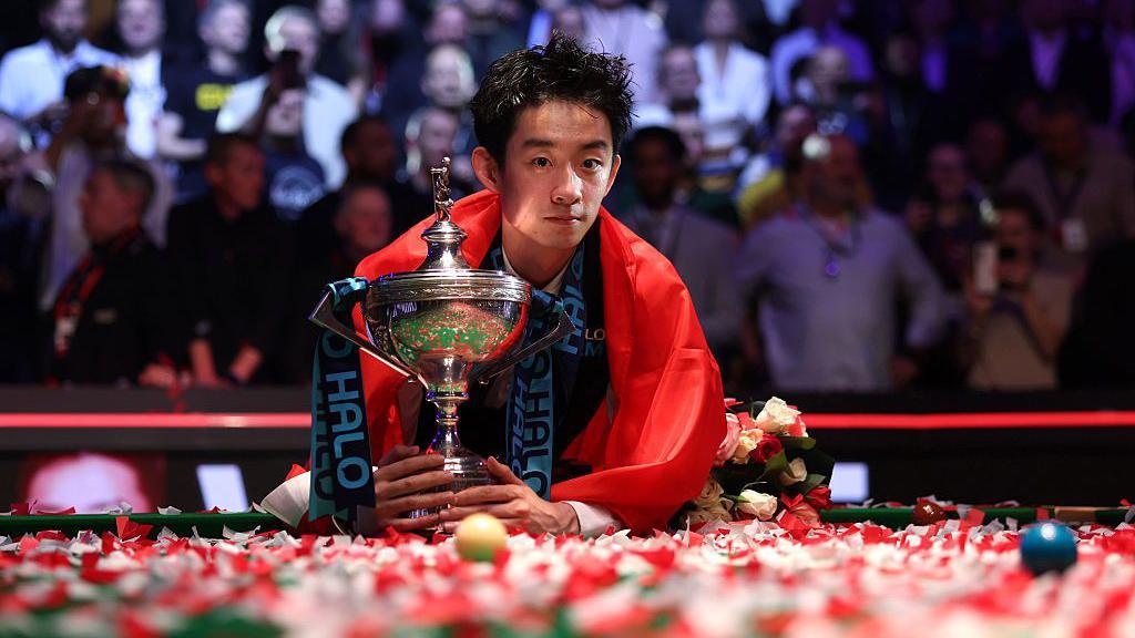 中國選手吳宜澤在奪冠後慶祝，並與世界斯諾克錦標賽獎盃合影。