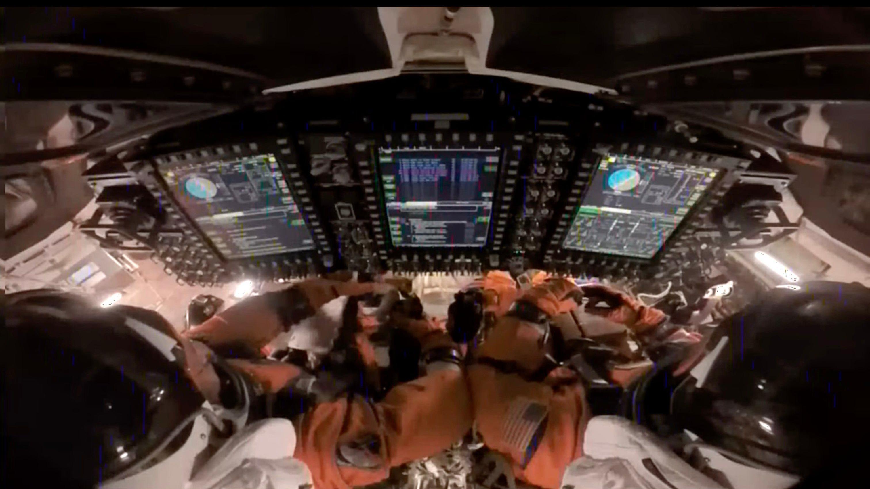En el interior de la cápsula Orion, los astronautas Reid Wiseman (izq.), comandante, y Victor Glover (der.), piloto, preparan la nave espacial Orion para el reingreso a la Tierra.
