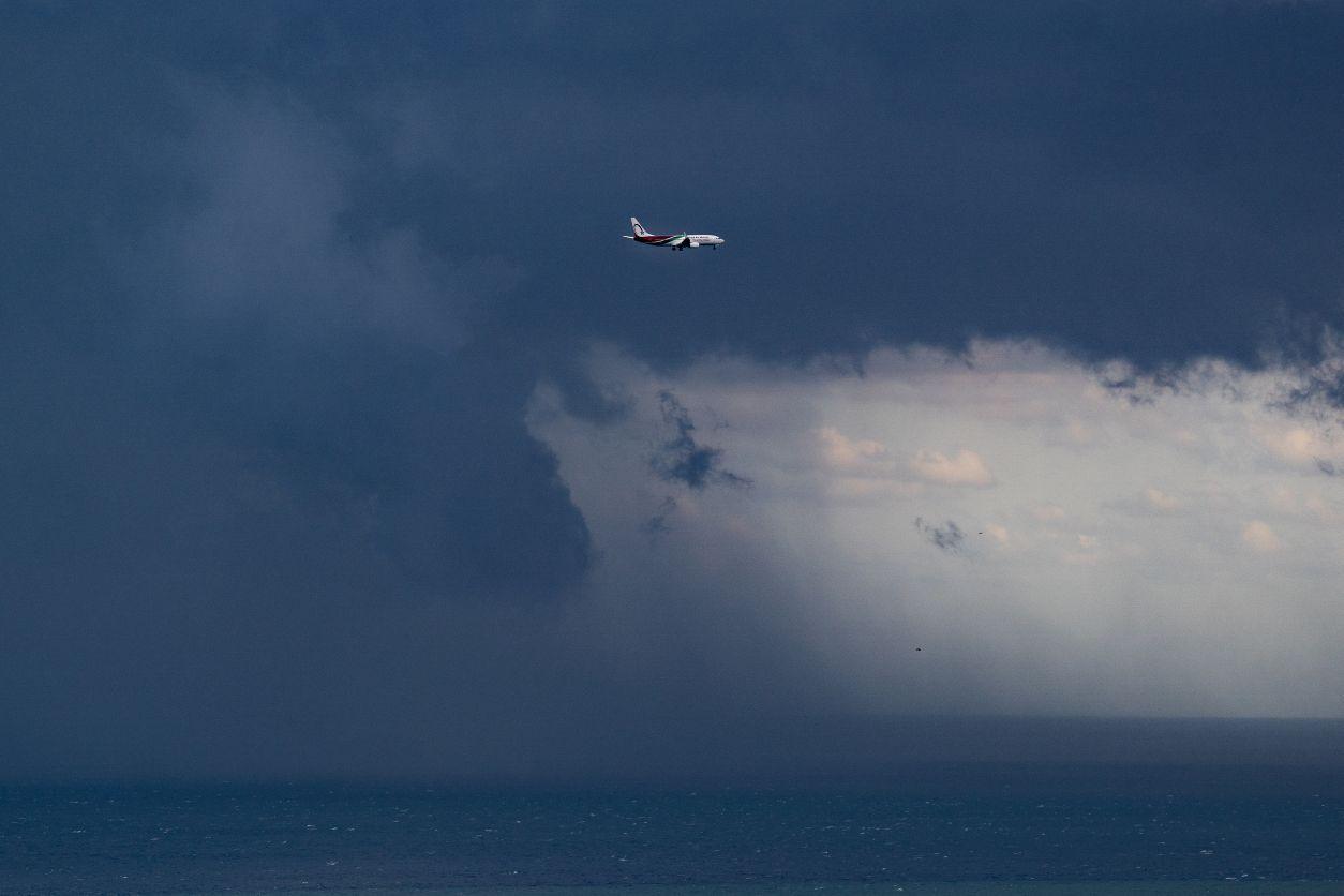 Um avião voa sobre o porto de Barcelona