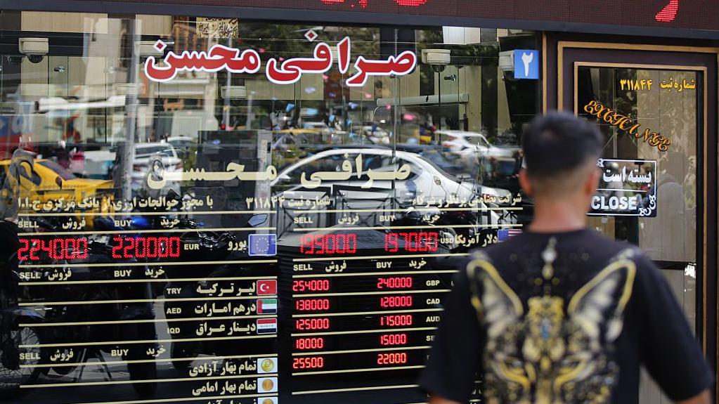 إيراني يعاين أسعار الصرافة