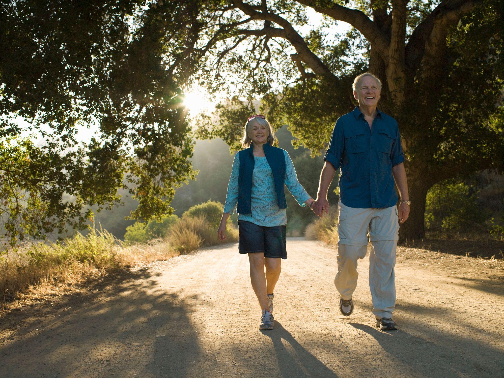 Una pareja cogida de la mano, caminando al atardecer
