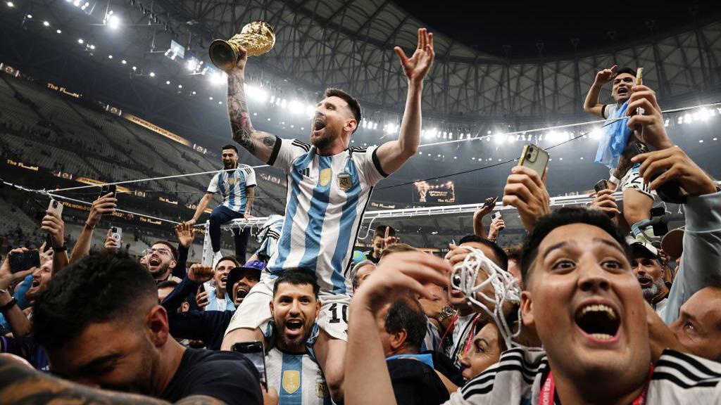 Lionel Messi comemora sentado nos ombros de Sergio Aguera no Catar, em 2022