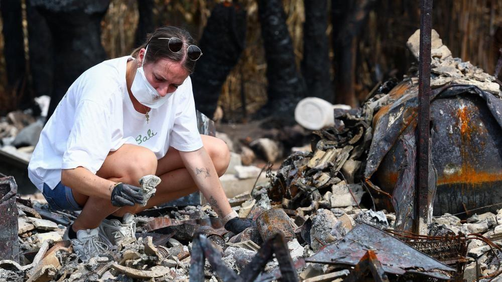 Julie inspeciona os destro&ccedil;os da casa de seus pais ap&oacute;s ela ter sido destru&iacute;da por um inc&ecirc;ndio florestal em Le Porge.
