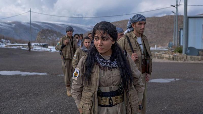 مقاتلون ومقاتلات من الحزب الديمقراطي الكردستاني الإيراني (ب د ك إ)  بزيهم العسكري يحملون السلاح ويشاركون في تدريب عسكري قرب أربيل في إقليم كردستان العراق، في يناير/ كانون الثاني الماضي.
