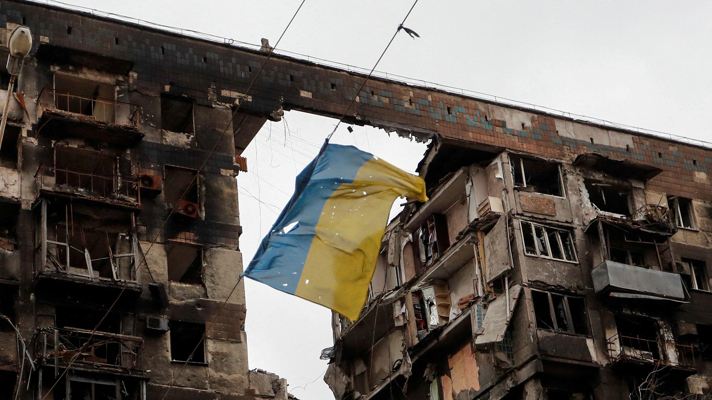 Zamrznuta ruska imovina: Šta hoće EU i zašto se Belgija protivi 2 Pocepana ukrajinska zastava visi između dve oštećene zgrade
