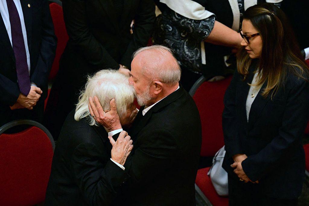 Lula da Silva le da un beso en la frente a Lucía Topolansky, esposa de José Mujica, al llegar al velatorio del expresidente uruguayo. La primera dama de Brasil, Janja, aguarda detrás para saludar.