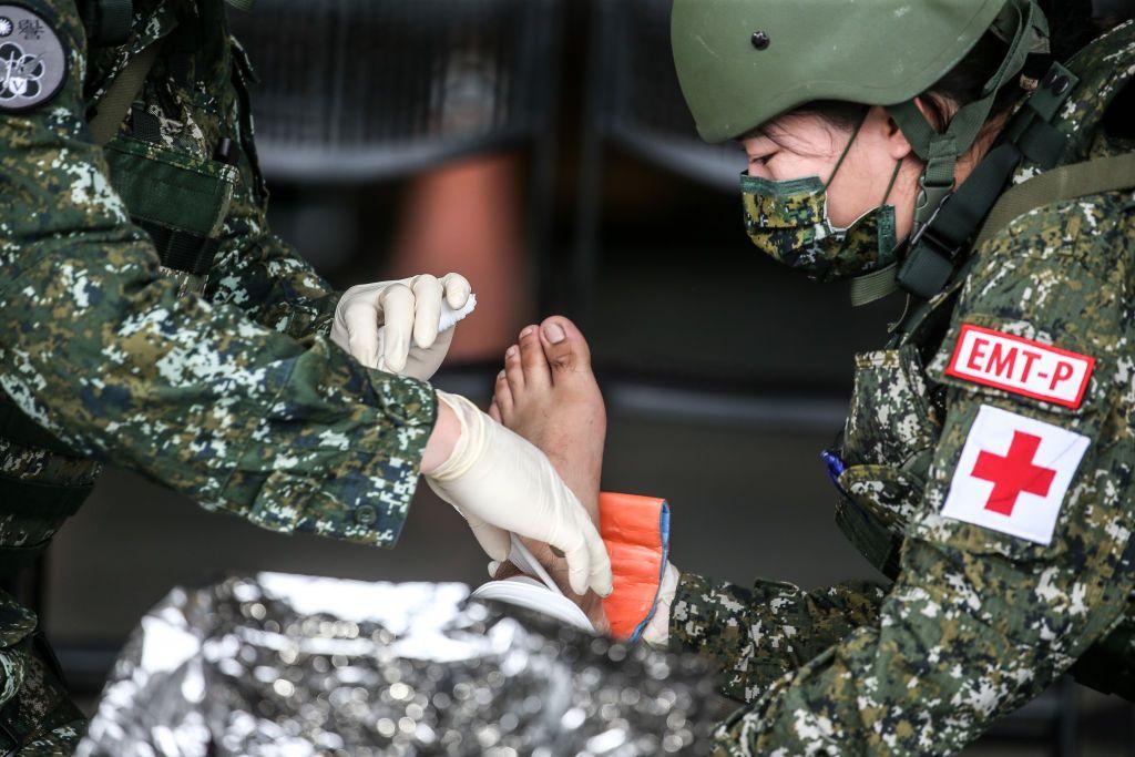 過去漢光演習一名女兵在演練包紮傷患。