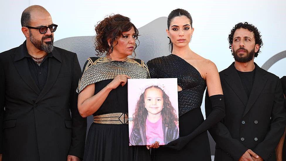 El actor Amer Hlehel, la directora del film Kaouther Ben Hania, la actriz jordano canadiense Saja Kilani y el actor palestino Motaz Malhees con una imagen de Hind Rajab.