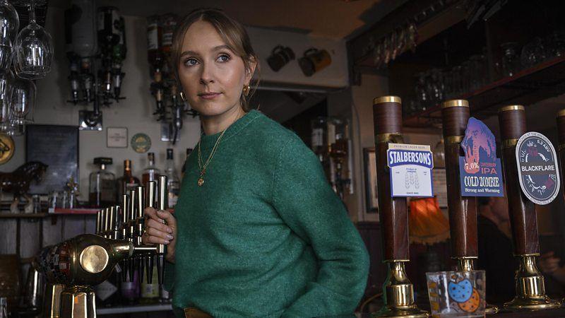 Rose Ayling-Ellis em um bar, em cena de 