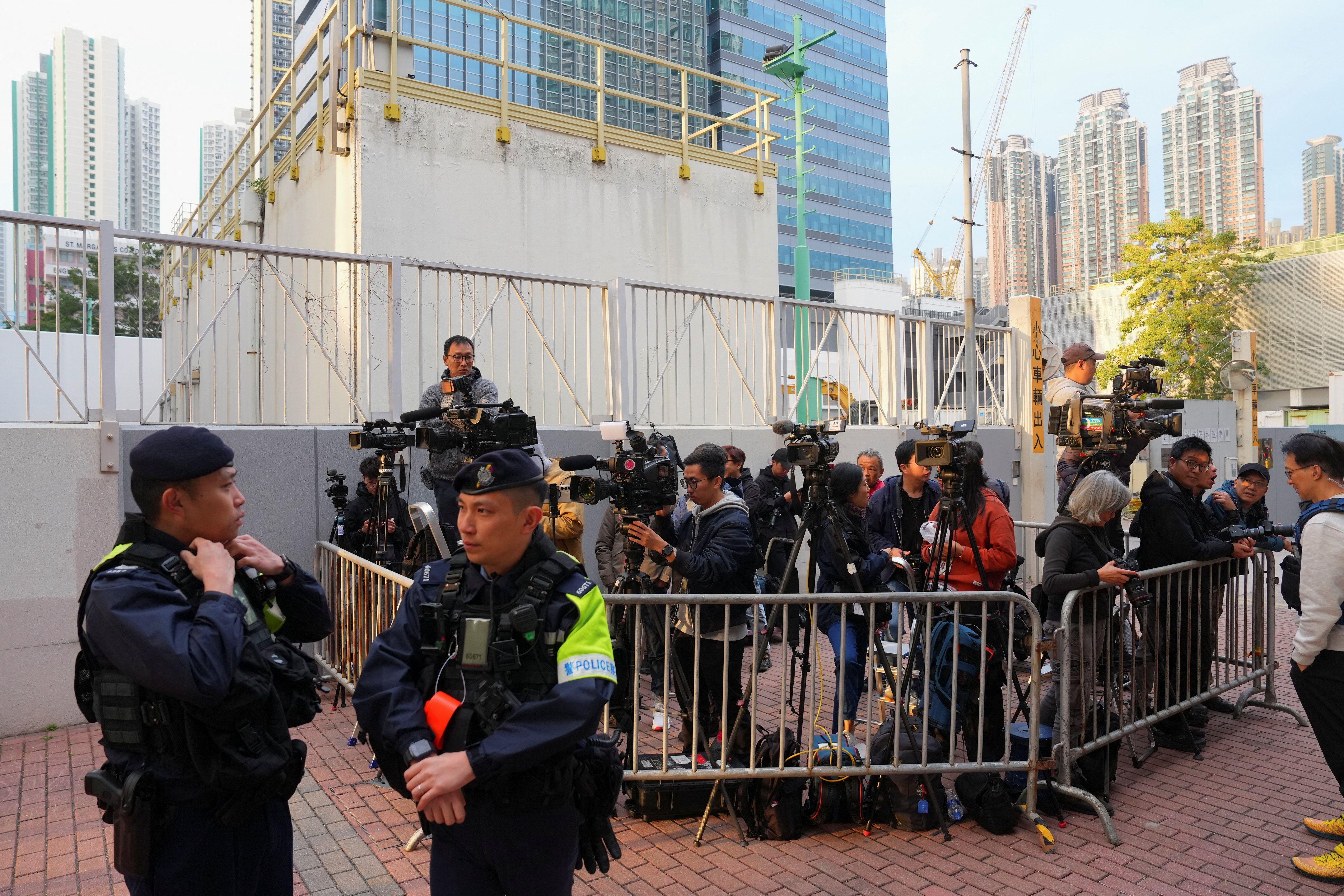 在香港，媒體記者在西九龍裁判法院大樓外的警戒線內等候，等待報道黎智英案件。