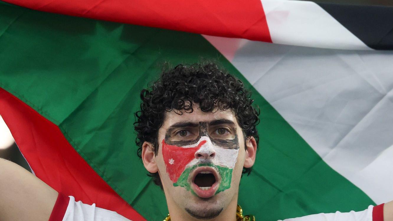  قام مشجع أردني بتلوين وجهه بألوان علم بلاده بينما كان يرفع العلم فوق رأسه قبل مباراة المجموعة العاشرة من كأس العالم 2026 بين الأردن والأرجنتين، والتي أقيمت في 27 يونيو/حزيران 2026 على ملعب دالاس في دالاس، تكساس.