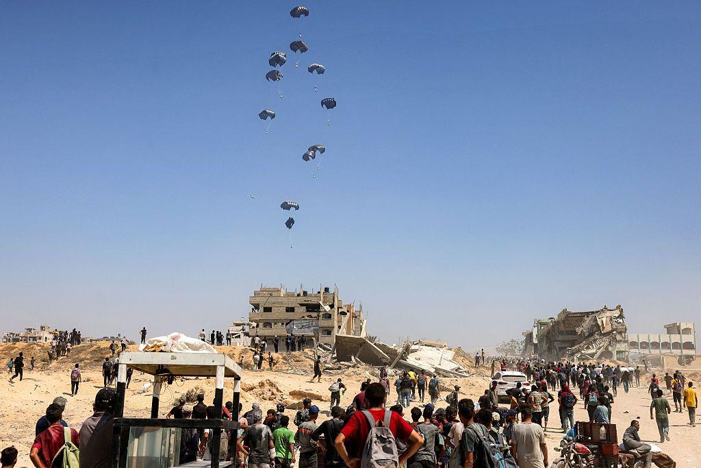 Palestinos observan un avión militar que lanza ayuda humanitaria -de Emiratos Árabes y Jordania- sobre el norte de la Franja de Gaza el 27 de julio de 2025.