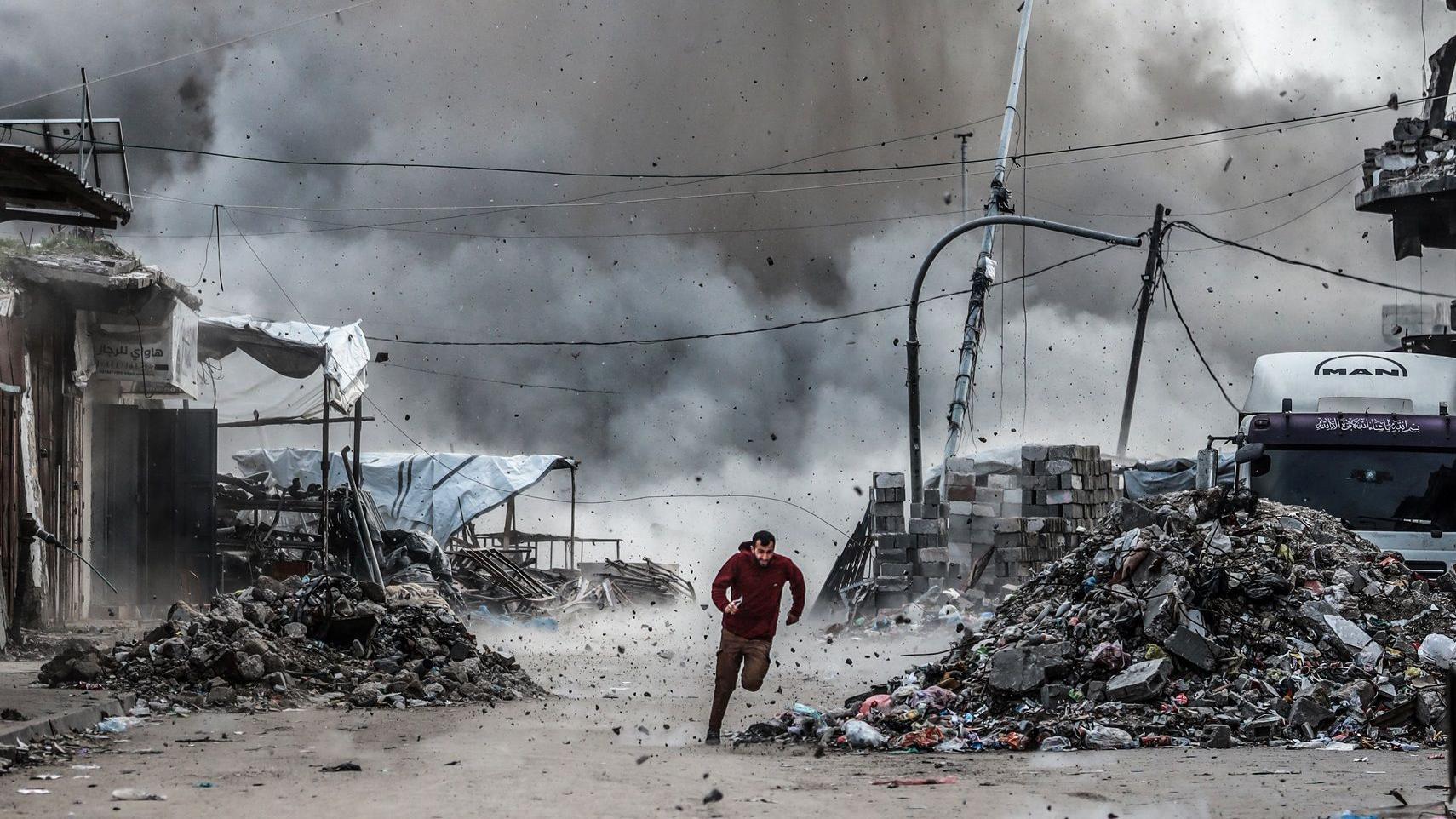 رجل يهرب من الأنقاض عقب الهجوم الإسرائيلي على مبنى من ثلاثة طوابق قرب تقاطع أسكولا في حي الزيتون، على الرغم من اتفاق وقف إطلاق النار في مدينة غزة، غزة، في 6 فبراير/شباط 2026.